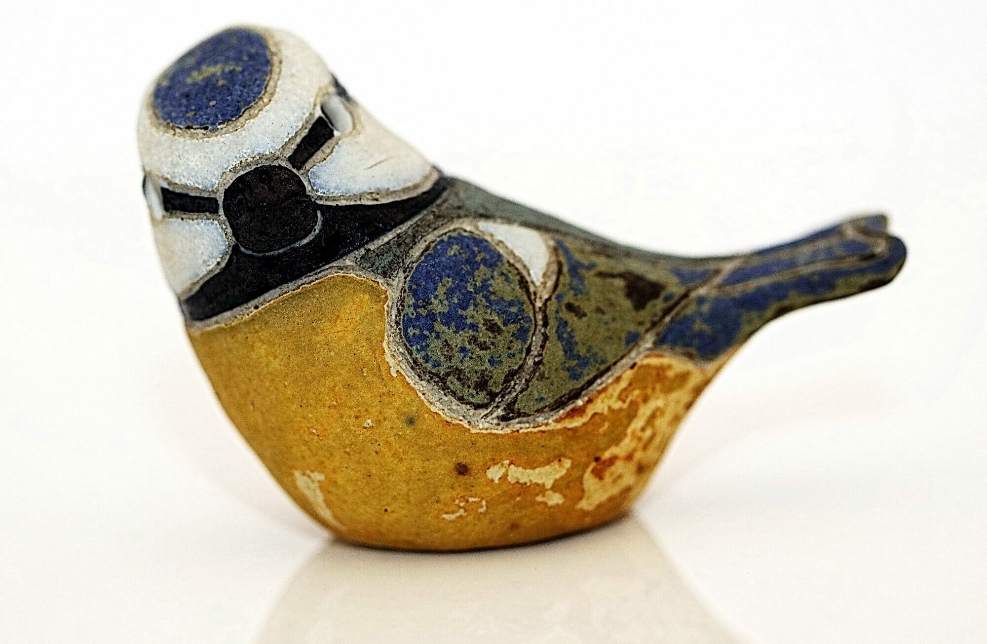 Pottery blue tit, approximately life-size, with a matt glaze, coloured blue and yellow. It is one of three pottery birds made in 1987 by Rosemary Wren and Peter Crotty from drawings from life.