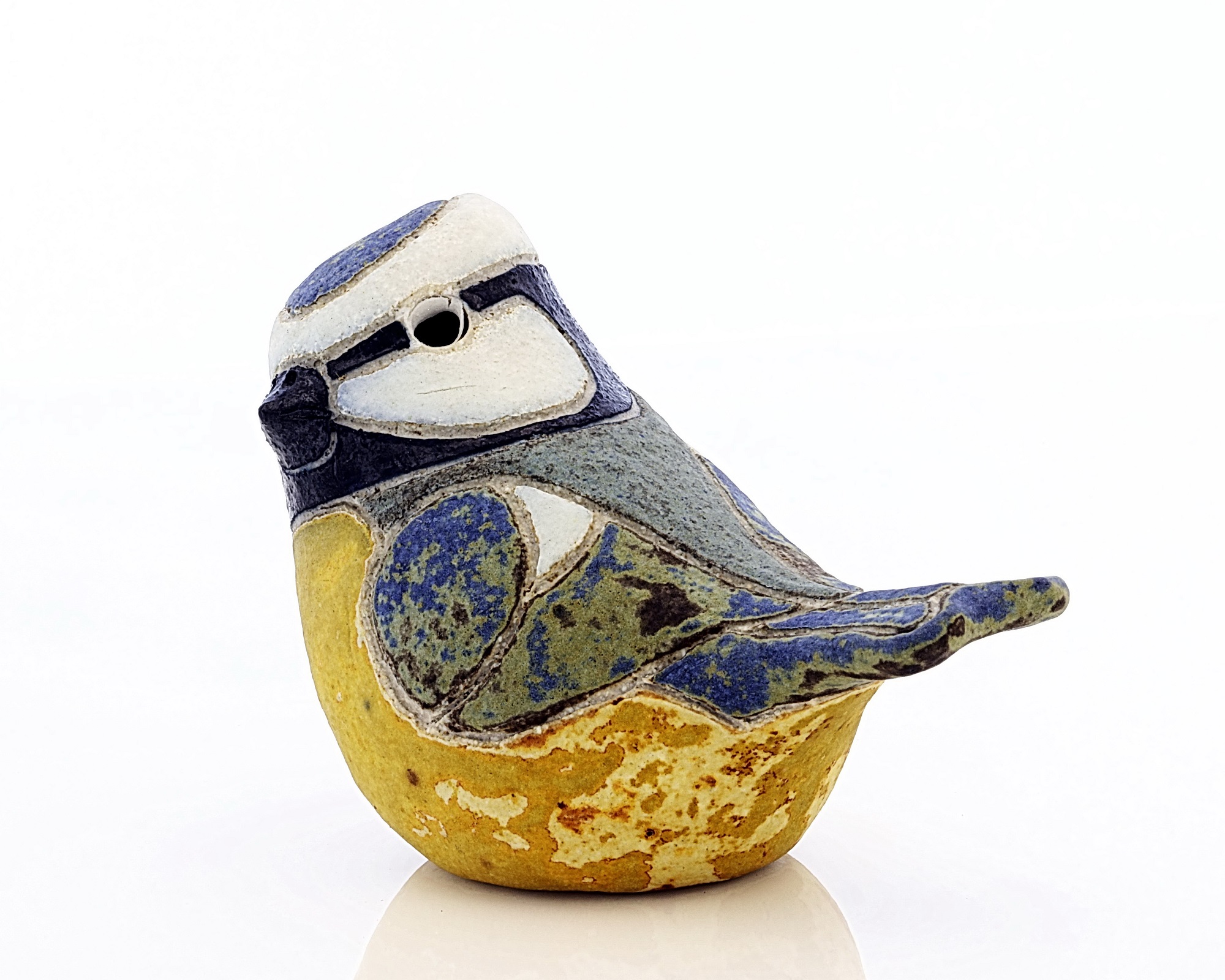 Pottery blue tit, approximately life-size, with a matt glaze, coloured blue and yellow. It is one of three pottery birds made in 1987 by Rosemary Wren and Peter Crotty from drawings from life.
