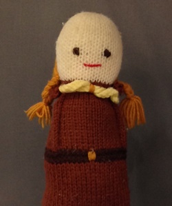 A doll depicting a Brownie Guide knitted by a Brownie from the 1st Hinchley Wood Brownie Pack, probably to earn their Knitter Badge.
