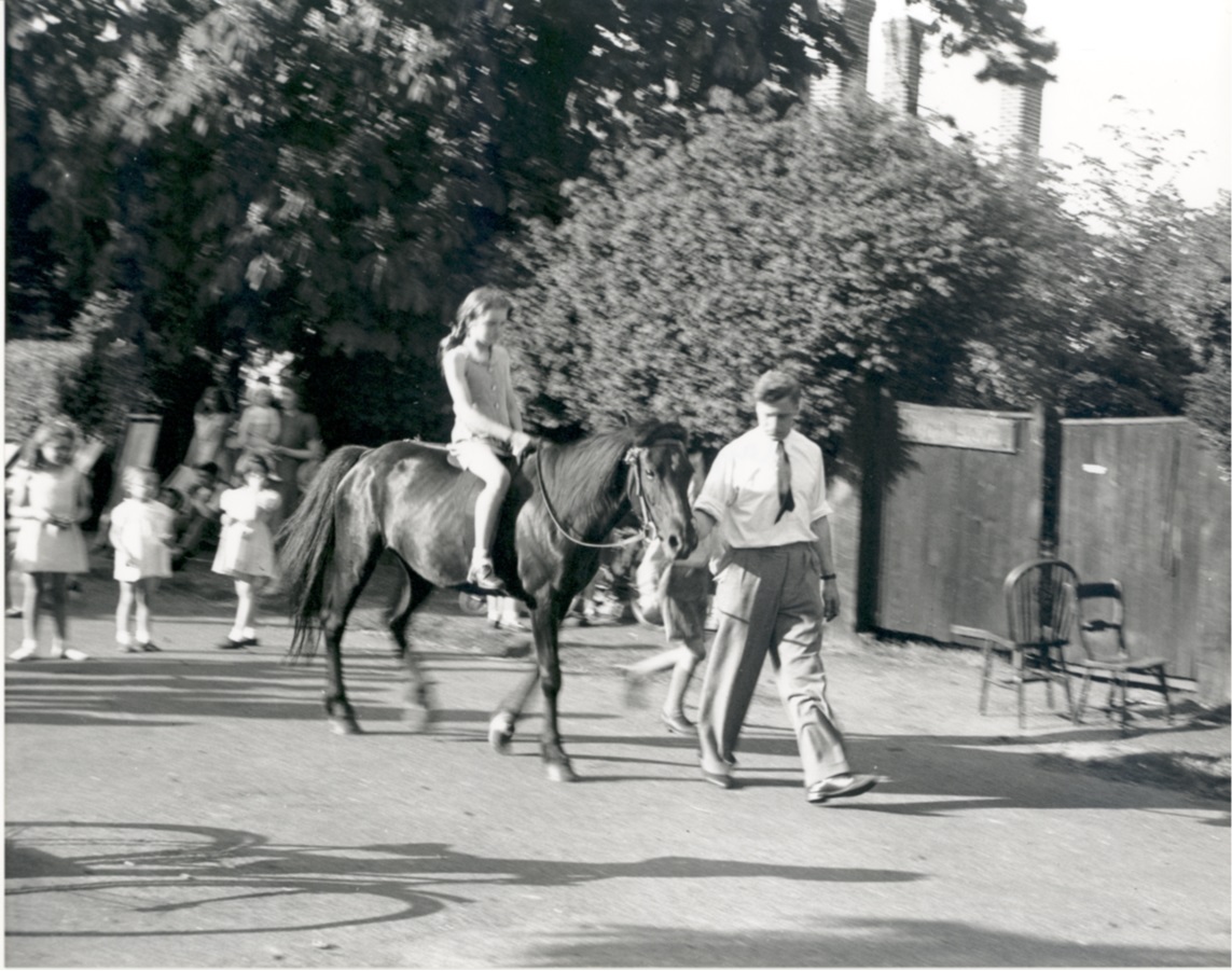 Image of a Victory Day Street party showing a young girl riding a pony.
