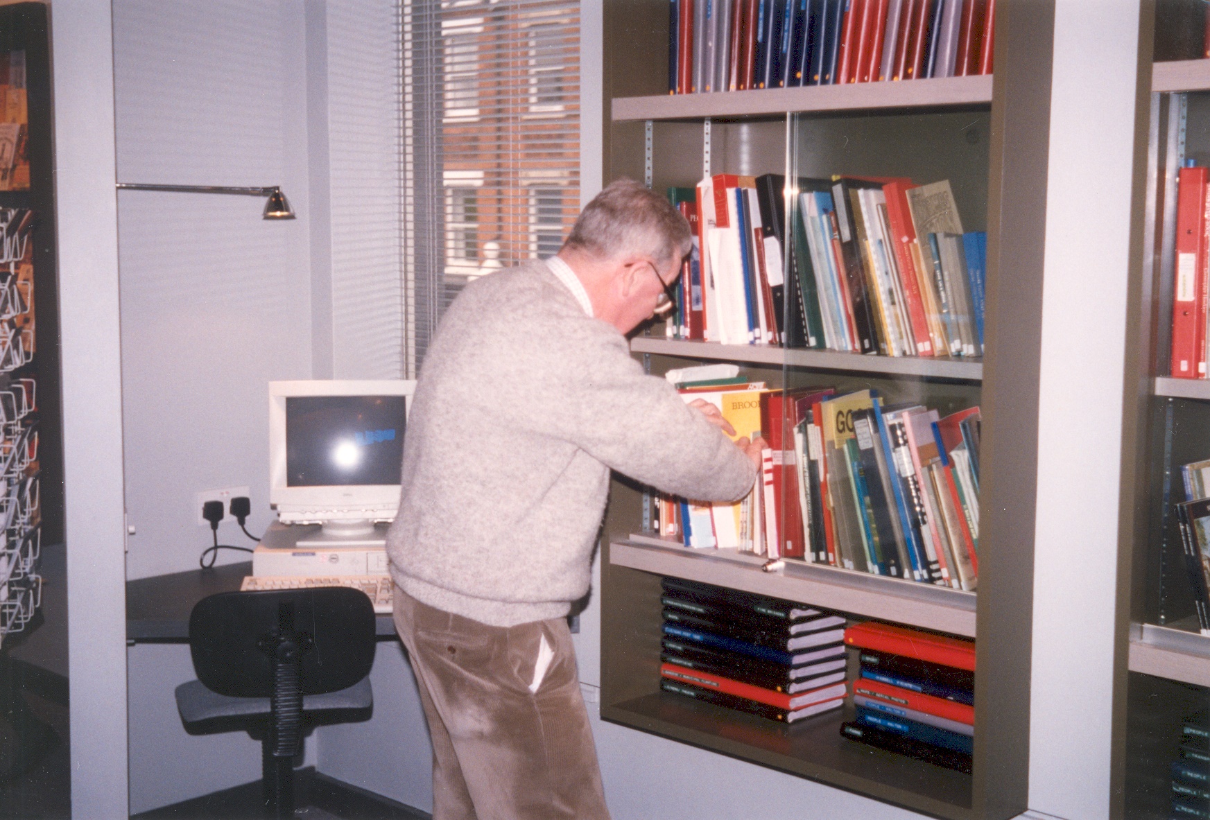 A visitor looking at reference books in the local studies area of the newly refurbished Elmbridge Museum, c.1996/7.