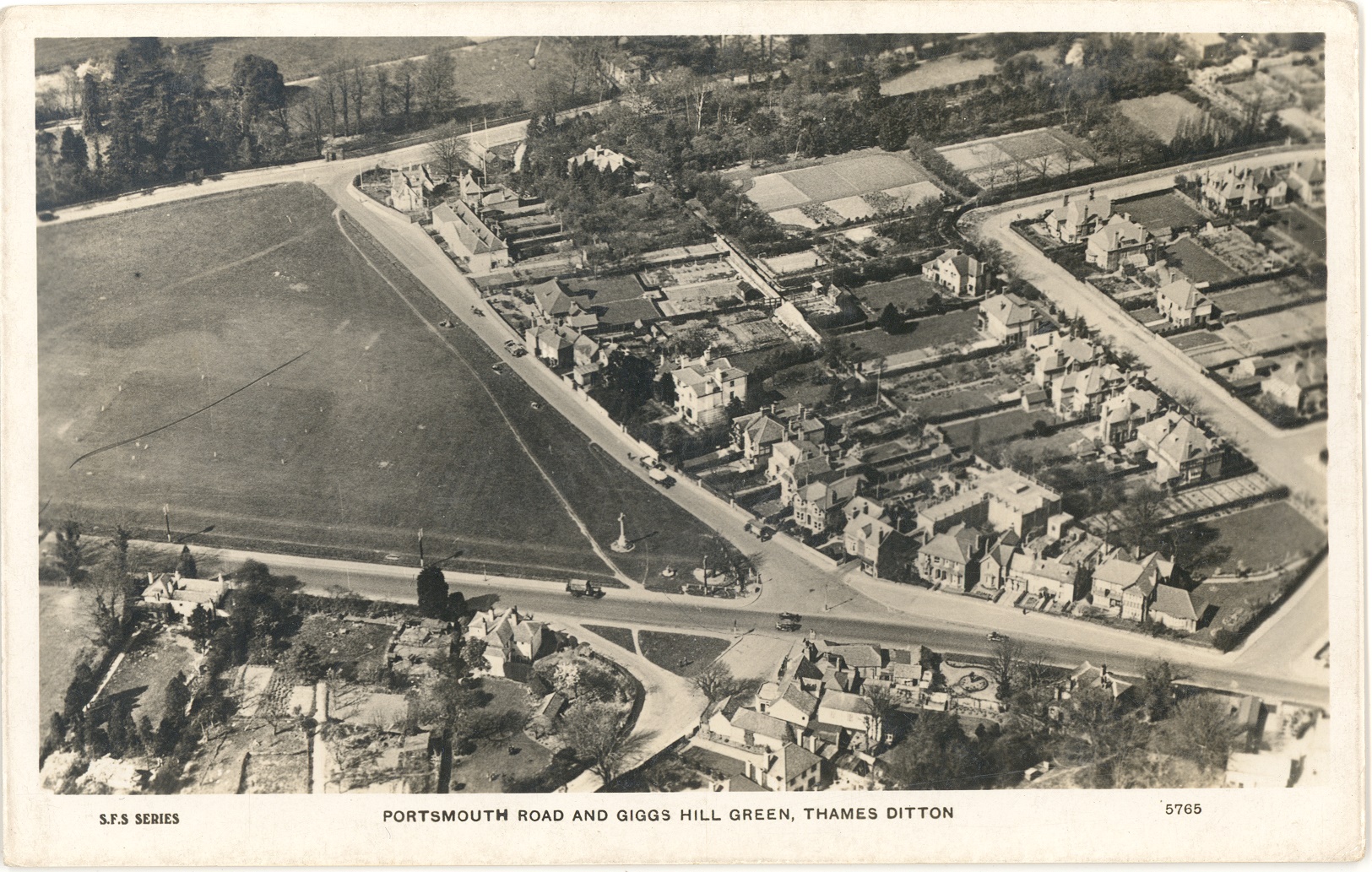 Postcard of an aerial view of Thames Ditton entitled 'Portsmouth Road and Giggs Hill Green.' Portsmouth Road is running along the bottom of the image.