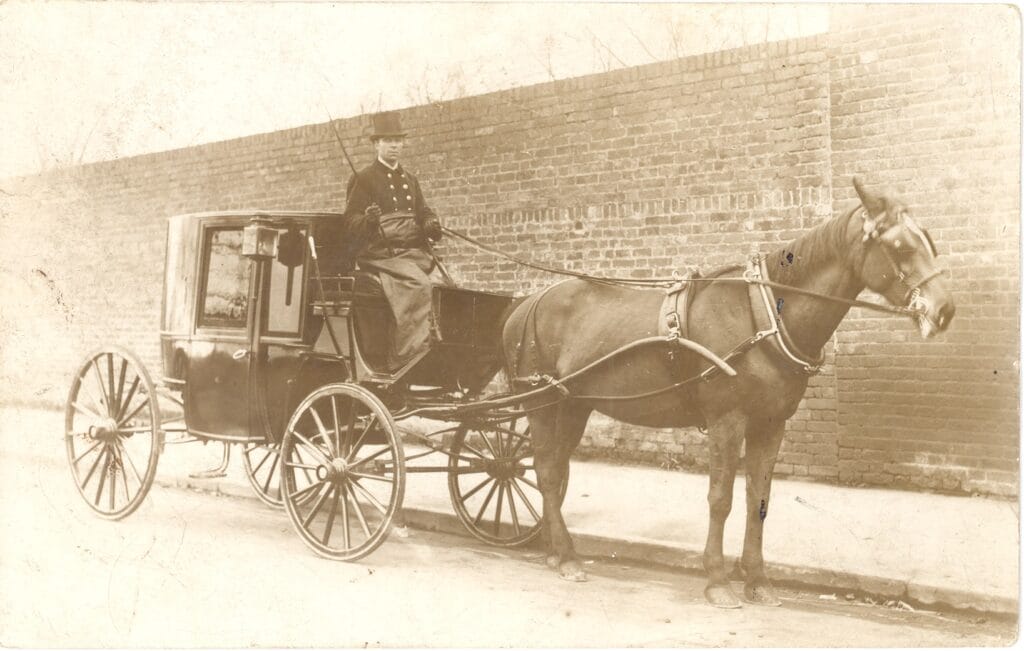Mr Nugus driving a horse-drawn cab from Weybridge station, 1918. He worked for Eli Boxall, who was a fly-proprietor.