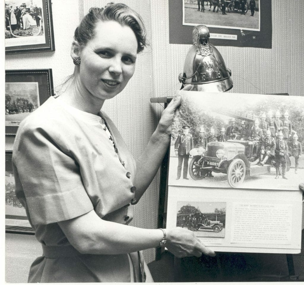 Photograph of Avril Landsdell holding up a photo donated to the museum, 1978.