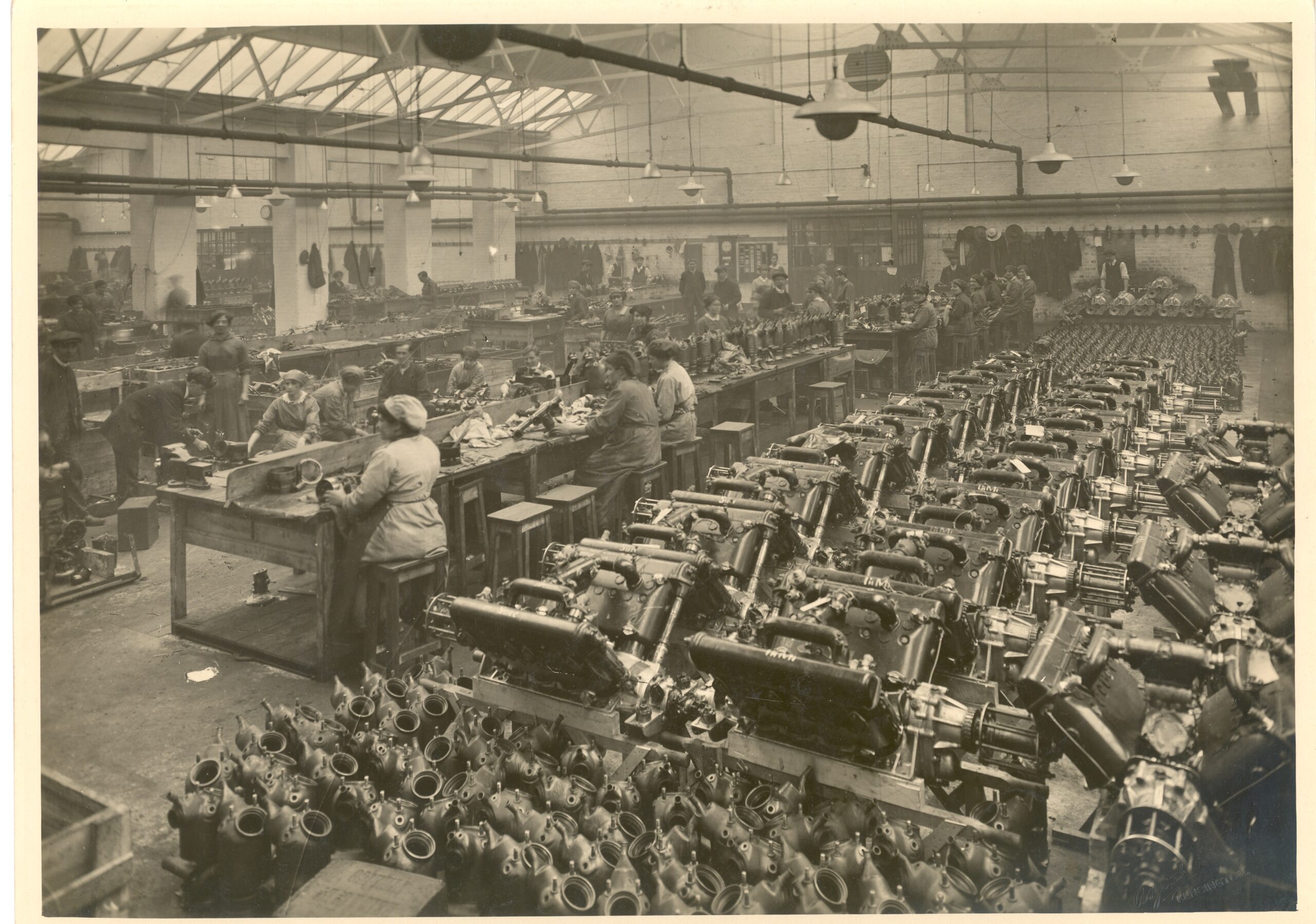 Black and white photograph showing the dismantling of Hispano Suiza aviation engines by female workers in the Gordon Watney & Co Ltd factory.