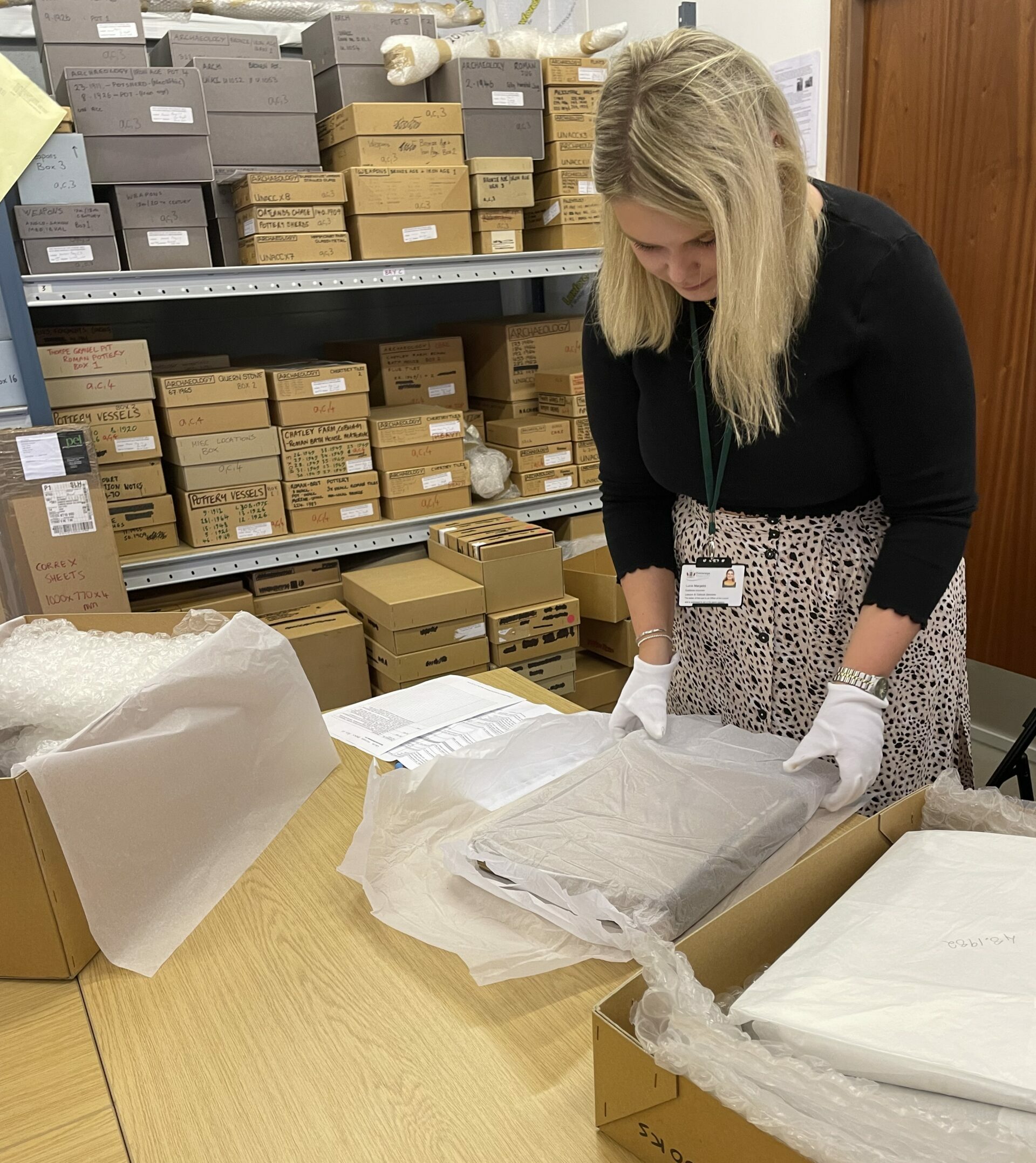 Photograph of Lucie looking through a box in the museum's stores.