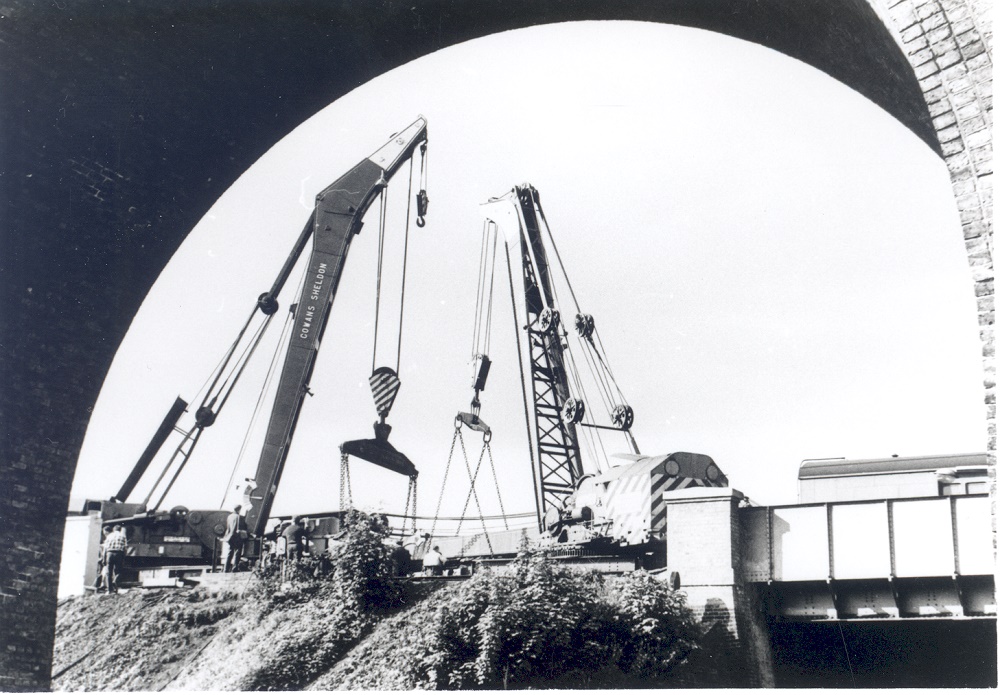 Image of breakdown crane at Long Ditton, Hampton Court Junction, Cranes lifting near the fly over bridge at Hampton Court Juncion, 1969. Seen through Angel Road bridge.