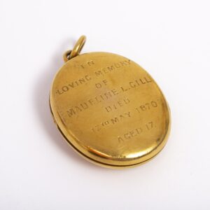 Oval Gold locket belonging to the Gill family. On the back of the locket is the inscription - In Loving Memory of Madeline L Gill, Died 17th May 1870, Aged 17.