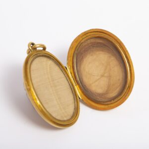 Oval Gold locket belonging to the Gill family. The inside of the locket contains a lock of Madeline Gill's hair.