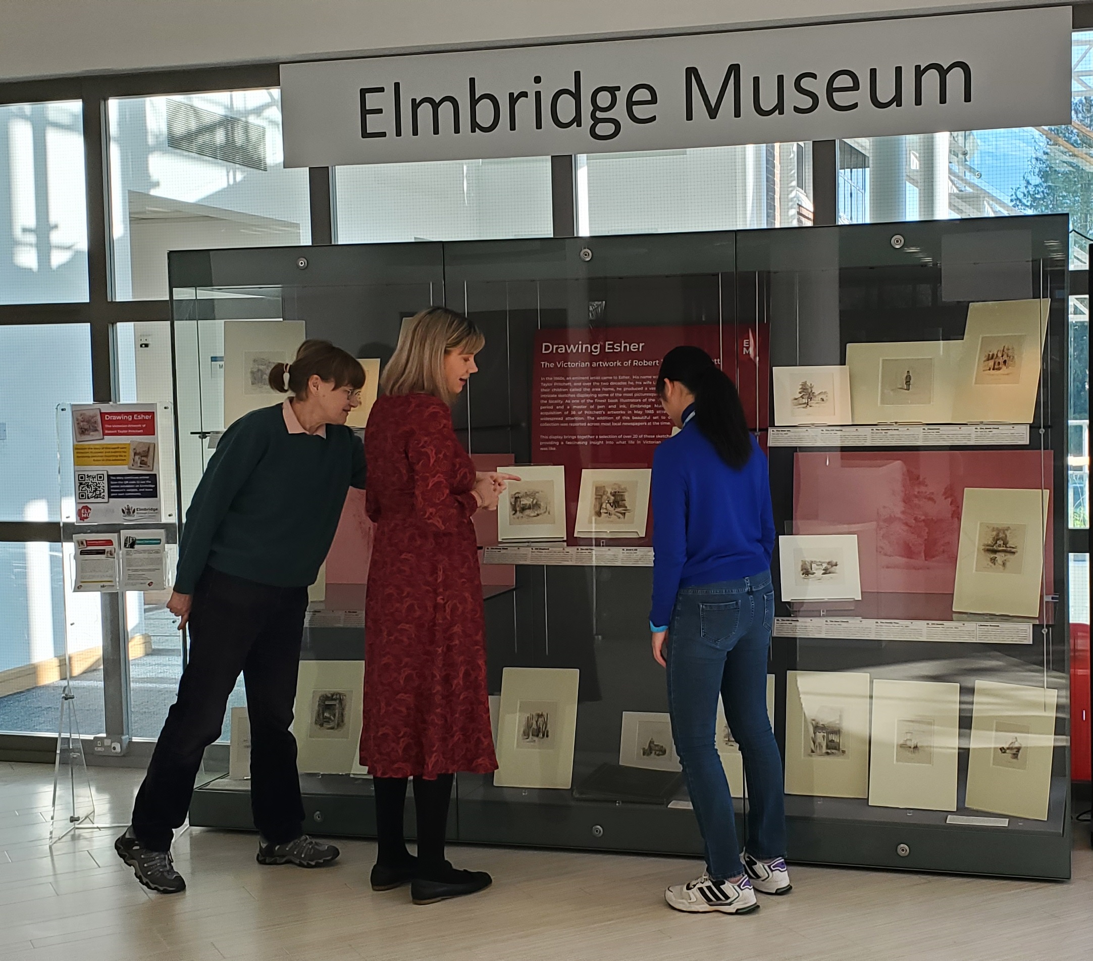 Carlie and museum staff looking at Drawing Esher exhibition