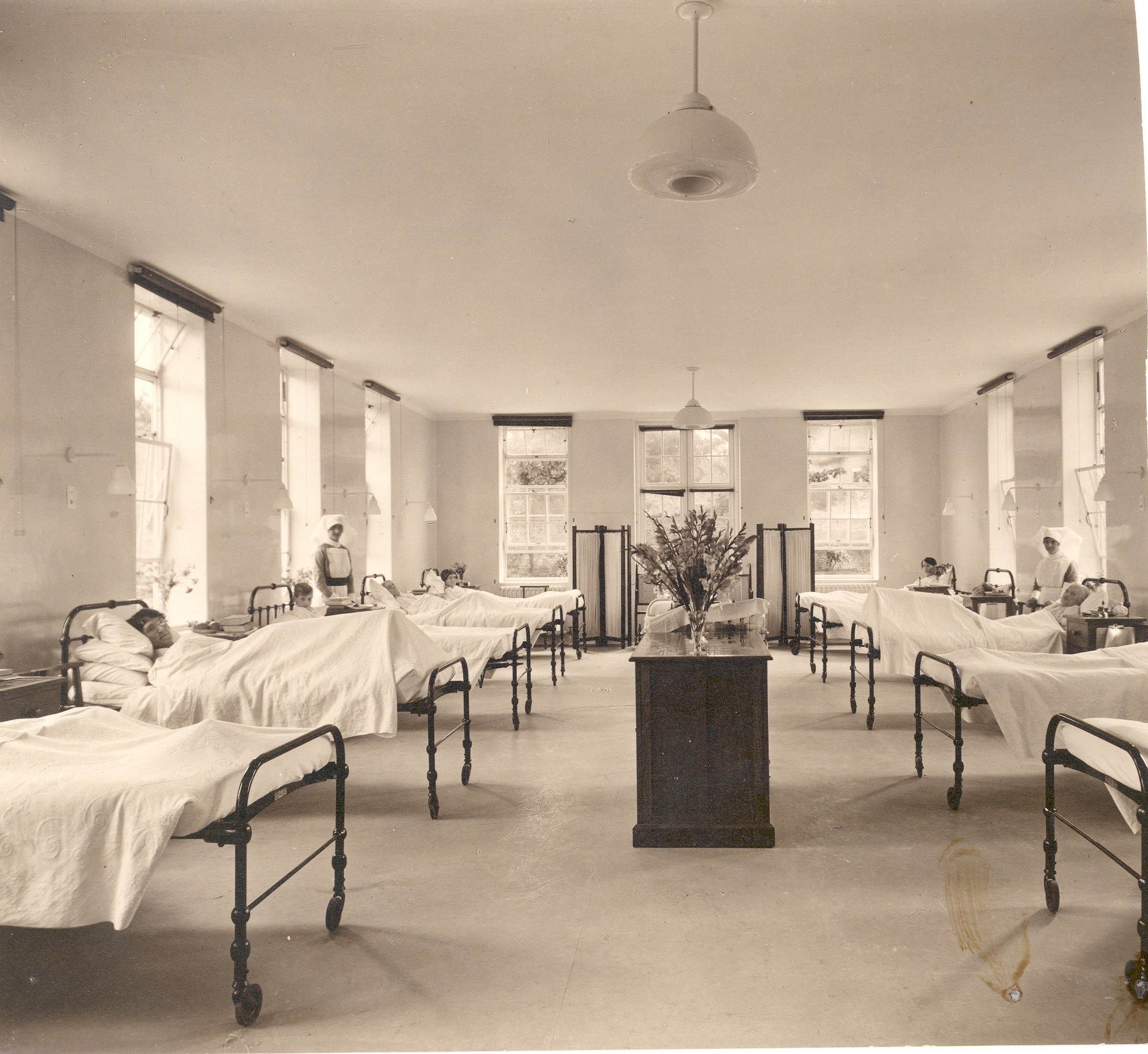 A ward inside the main Weybridge Cottage Hospital, Church Street, showing patients in beds and nurses in uniform. Undated but post-1928.
